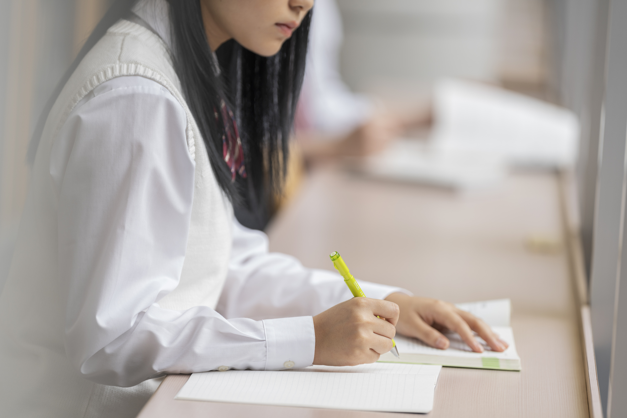 ノートと教材を使い、自分で学習を進める高校生
